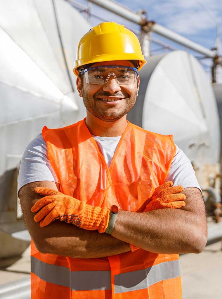 smiling-african-engineer-standing-at-industrial-si-SMSQDNQ.jpg